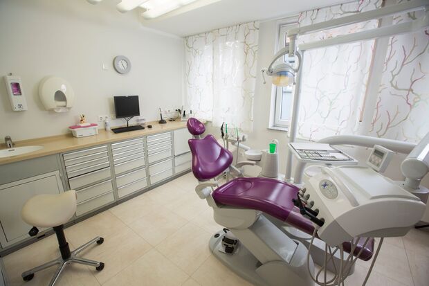 Modernes Zahnarzt-Behandlungszimmer mit Behandlungsstuhl und Zahnarztmöbeln