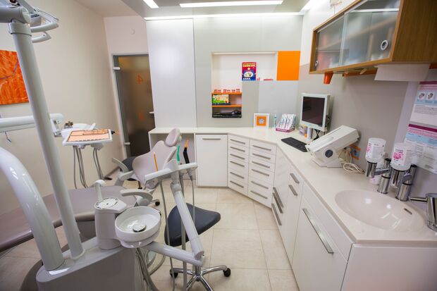 Modernes Zahnarzt-Behandlungszimmer mit Behandlungsstuhl und Zahnarztmöbeln