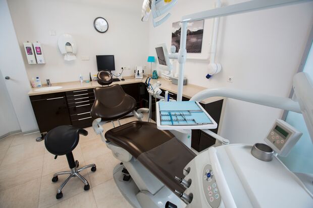 Modernes Zahnarzt-Behandlungszimmer mit Behandlungsstuhl und Zahnarztmöbeln